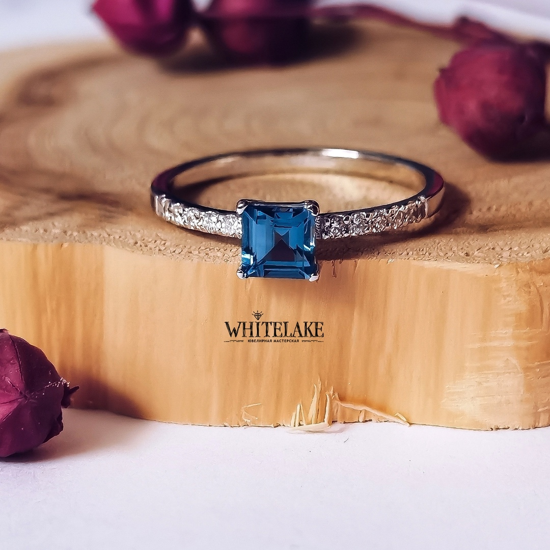 Стильное помолвочное кольцо из белое золота с топазом London blue на светлом фоне